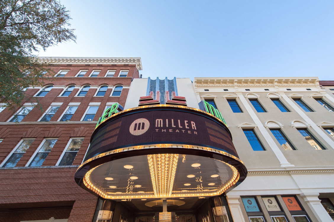 The illuminated marquee of the Miller Theater, displaying the theater's name in bold letters, set against the historic building facade.